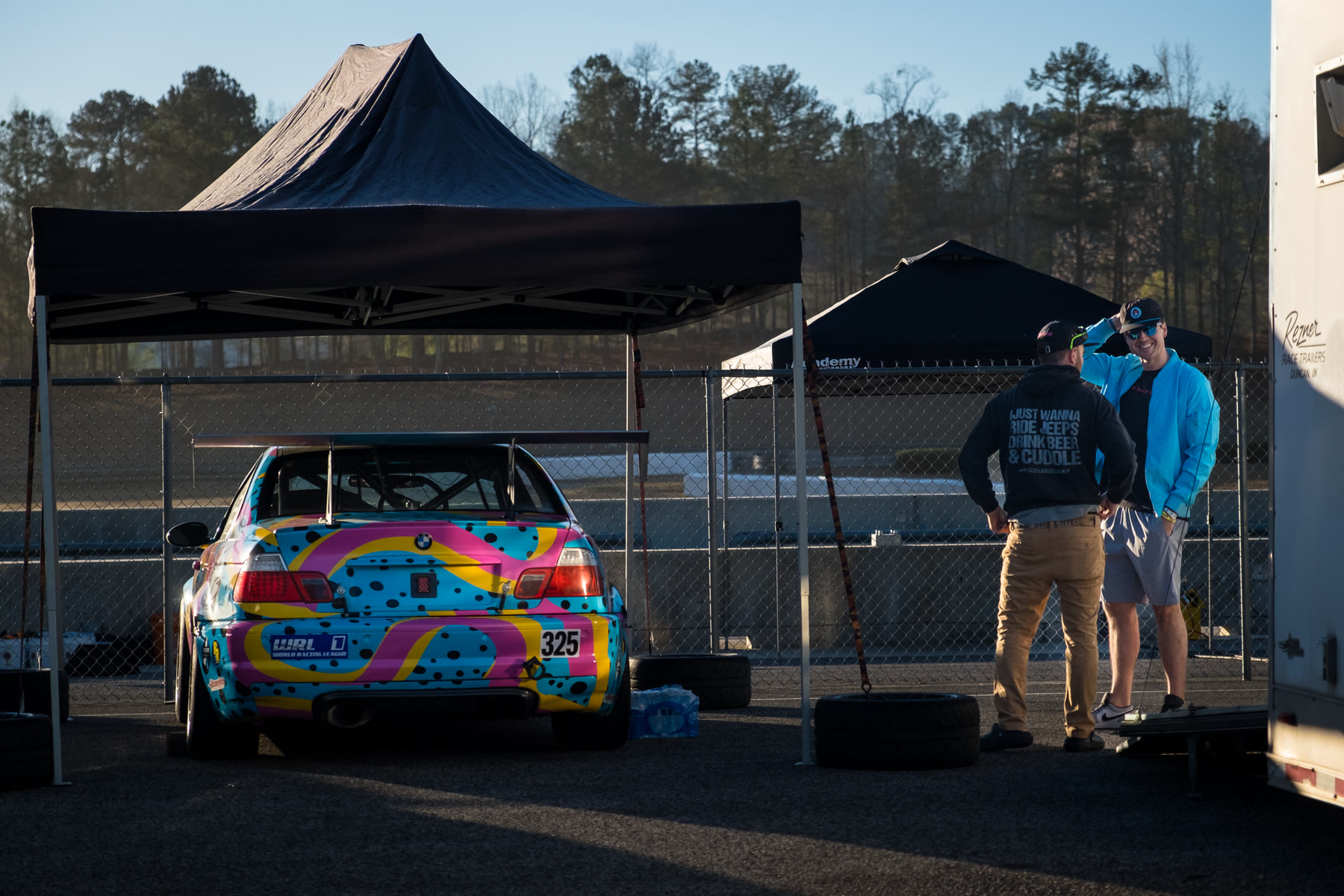 Cody and a teammate standing beside the XEPA Racing car in the paddock
