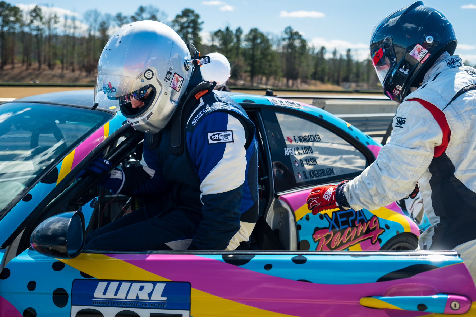 Cody climbing into the brightly liveried XEPA Racing car during a driver change